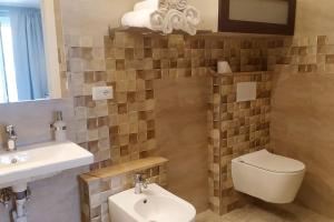 a bathroom with a toilet and a sink at Villino rosso in Taormina
