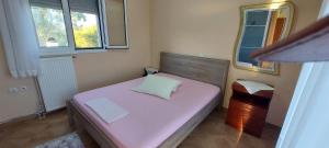 a small bedroom with a bed and a mirror at Billy's apartments in Artemida