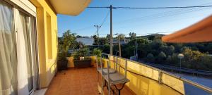 a balcony with a bench on a yellow building at Billy's apartments in Artemida