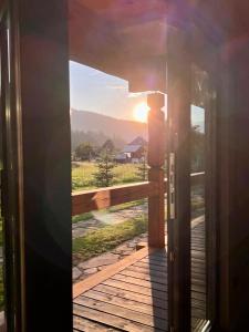 una puerta abierta a un balcón con puesta de sol en Chalet PidStromom en Mykulychyn