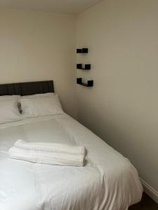 a white bed with two white towels on it at Stunning Double room one in Bedford