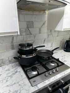 two pots and pans sitting on a stove in a kitchen at Stunning Double room one in Bedford
