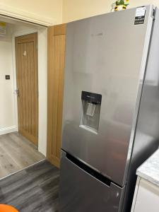 a stainless steel refrigerator in a kitchen at Stunning Double room one in Bedford