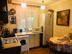 a kitchen with a refrigerator and a table with a microwave at Domik v lesy in Lyutezh