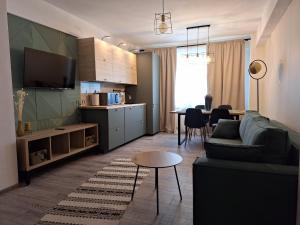 a living room with a couch and a table and a kitchen at CITADEL VIEW in Tîrgu Neamţ