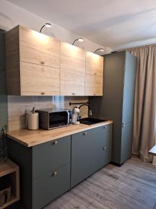 eine Küche mit Holzschränken und einer Mikrowelle auf der Theke in der Unterkunft CITADEL VIEW in Târgu Neamţ