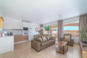 cocina y sala de estar con sofá y mesa en Villas Monte Solana, en Morro del Jable