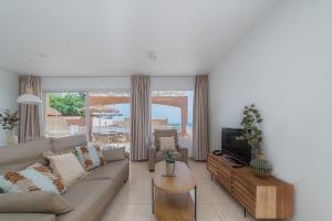 uma sala de estar com um sofá e uma televisão em Villas Monte Solana em Morro del Jable