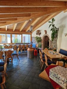 ein Restaurant mit Holzdecken, Tischen und Stühlen in der Unterkunft Ferienwohnung Haus Sonnenblick in Burkhardtsdorf