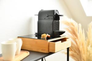 een koffiezetapparaat op een tafel met een doos bij MILPAU Bottrop 3 - Modernes und zentrales Premium-Apartment mit Queensize-Bett - Netflix, Nespresso und Smart-TV in Bottrop