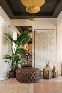 a lobby with a brown ottoman and a plant at Hotel Mazzanti in Milano Marittima