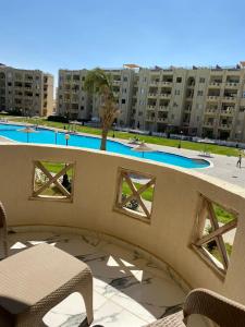 uma vista para uma piscina a partir da varanda de um edifício em North coast em Alexandria