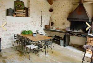 een eetkamer met een tafel en stoelen en een oven bij Maison 3 chambres cour/bassin in Pernes-les-Fontaines