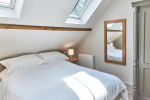 a bedroom with a white bed and a mirror at The Smithy in Hexham