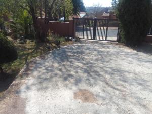 a driveway with a gate in a yard at Room2rent Centurion in Pretoria
