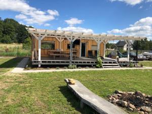 a wooden cabin with a bench in the grass at Radaczowa Chatka 