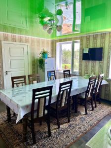 Kochkorka的住宿－MALIKA Guest House，大型用餐室配有大桌子和椅子