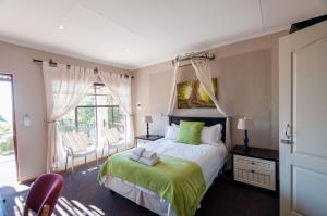 a bedroom with a large bed with a green blanket at Zuikerkop Country Game Lodge in Clocolan