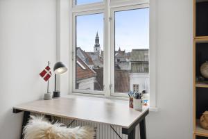 einen Schreibtisch in einem Zimmer mit Fenster in der Unterkunft Lejlighed i hjertet af Aalborg in Aalborg