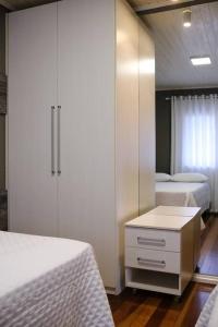 a bedroom with two beds and a dresser and a closet at Casa de Campo Warmup in Caxias do Sul