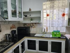 una cocina con armarios blancos y fregadero en MauriSoleil Villa Privée avec Piscine - Flic en Flac, en Flic en Flac