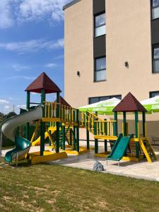a playground with a slide and chairs in front of a building at Arena Bakarni in Brčko