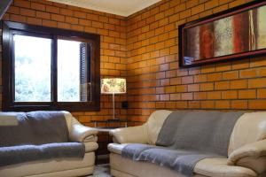 a living room with two couches and a brick wall at Casa de Campo Warmup in Caxias do Sul