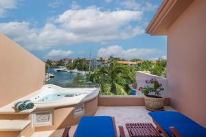 einen Balkon mit einer Badewanne und Blick auf das Wasser in der Unterkunft Rent Portobello Marina y Villas in Puerto Aventuras