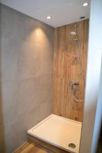 y baño con ducha y pared de madera. en Loft spa et wellness Obanoa, en Vaux-sur-Sûre