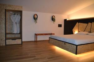 1 dormitorio con 1 cama grande y espejo en Loft spa et wellness Obanoa, en Vaux-sur-Sûre