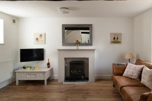 a living room with a couch and a fireplace at The Milking Parlour in Malmesbury