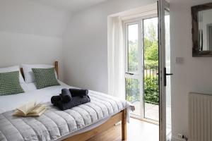 a bedroom with a bed with a book on it at The Milking Parlour in Malmesbury