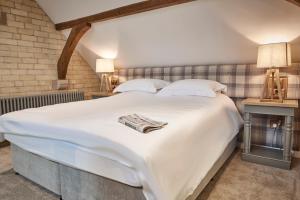 a large white bed in a room with a brick wall at The Foal in Hexham