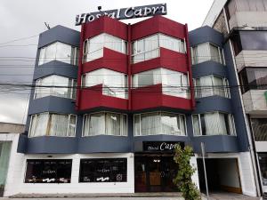 een rood en blauw gebouw met een bord erop bij Hostal Capri in Quito