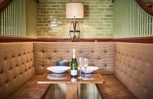 a table with two glasses and a bottle of wine at The Stallion in Hexham