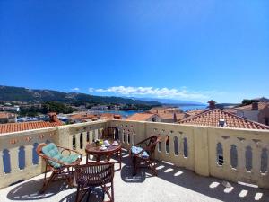 a patio with chairs and a table on a balcony at Old Town Arbia in Rab