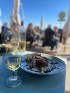 a plate of food and a glass of wine on a table at Très bel appartement cosy in Palavas-les-Flots