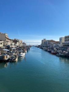 une rivière avec des bateaux dans une ville avec des bâtiments dans l'établissement Très bel appartement cosy, à Palavas-les-Flots