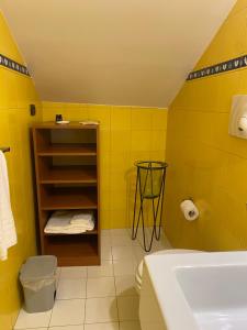 Baño amarillo con lavabo y aseo en Bed & Breakfast Casa Anna Rita, en Vietri