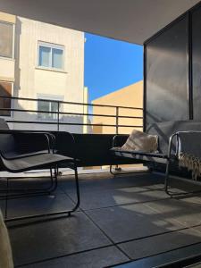 balkon z 2 krzesłami i dużym oknem w obiekcie Très bel appartement cosy w mieście Palavas-les-Flots