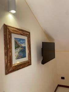 a painting and a television on a wall at Bed & Breakfast Casa Anna Rita in Vietri sul Mare