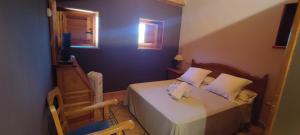 1 dormitorio pequeño con 1 cama y 1 silla en Posada de Serrada, en Serrada de la Fuente