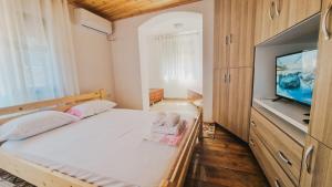 a bedroom with a bed and a flat screen tv at Guesthouse Kroi City Center in Berat
