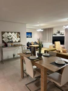 uma sala de jantar e sala de estar com uma mesa de madeira e cadeiras em Appartement Marina Casablanca em Casablanca