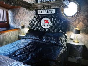 a bedroom with a bed with a black head board at Titanic Boat in Liverpool