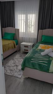 1 Schlafzimmer mit 2 Betten mit grüner Bettwäsche und einem Tisch in der Unterkunft Tarabya Family Suıt Villa in Istanbul