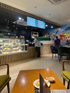 a person standing at the counter of a fast food restaurant at Zulanie Suite Troika Residence, SPACIOUS AND COZY WITH POOL, Free Wifi & Netflix in Golden Triangle of Kota Bharu in Kota Bharu