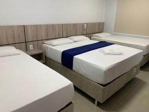 a room with three beds in a room at Hotel Seven in Goiânia