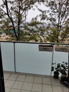 a balcony with white doors and potted plants at 巴塞之家 in Montcada i Reixac