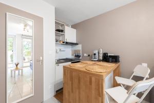 eine Küche mit einer Theke und Stühlen in einem Zimmer in der Unterkunft Les Terrasses de Rangueil : studio avec parking in Toulouse